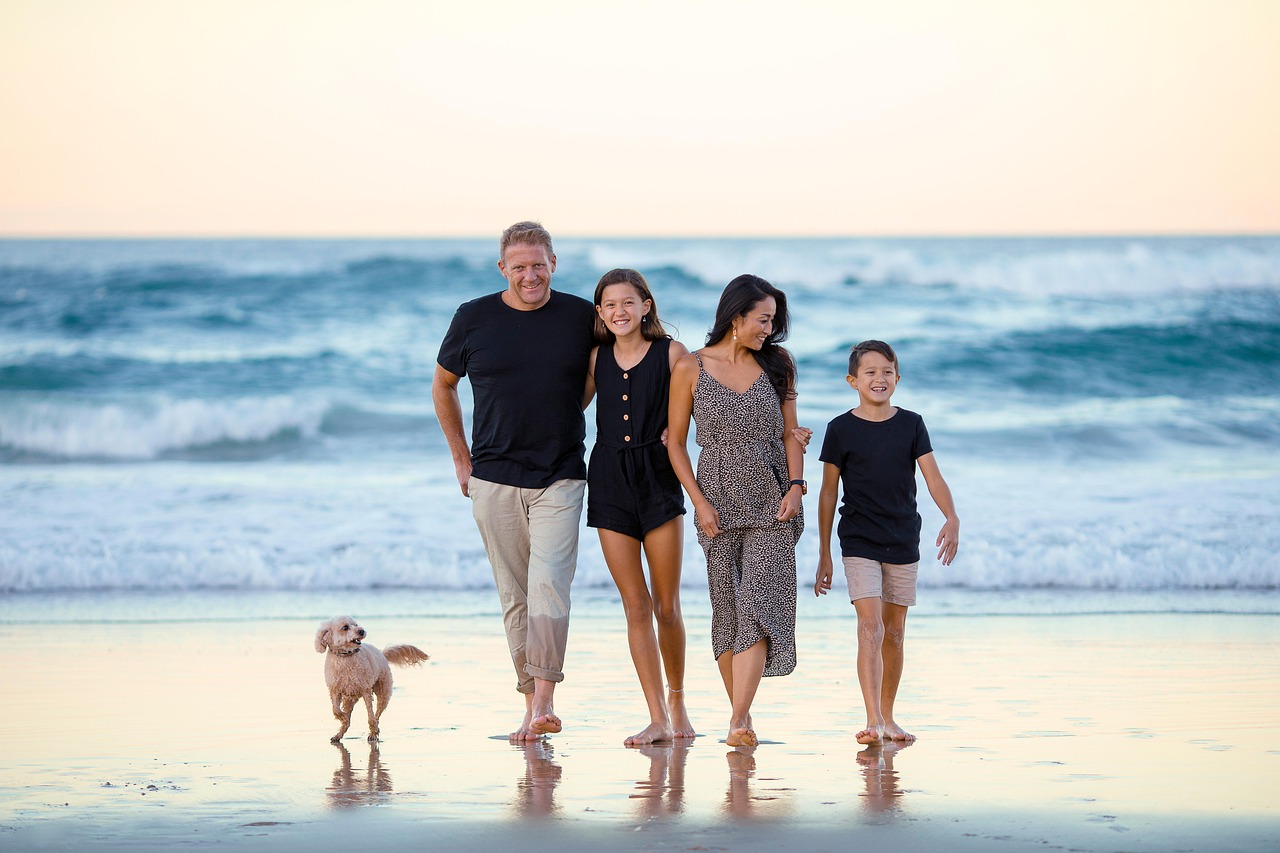 Familie spaziert lachend am Strand